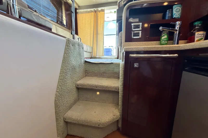 Slide: The Image of Interior of 2010 Sea Ray 390 Sedan Bridge with carpeted stairs and kitchenette. - 95