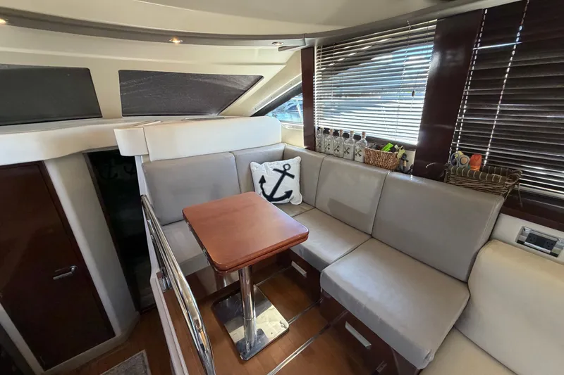 Slide: The Image of Luxurious interior of 2010 Sea Ray 390 Sedan Bridge with elegant seating and wooden table. - 55
