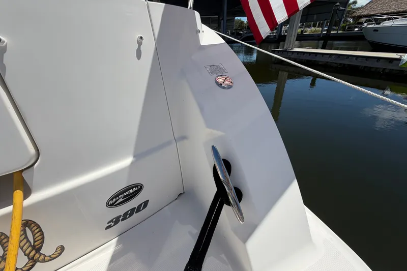 Slide: The Image of 2010 Sea Ray 390 Sedan Bridge boat docked, featuring MarineMax branding and American flag. - 21