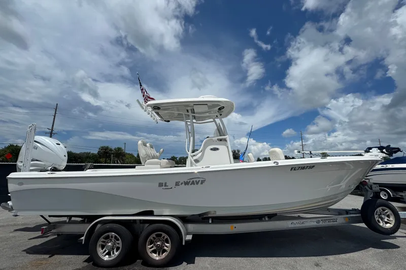 Slide: The Image of 2019 Blue Wave 2800 Pure Hybrid boat on trailer under cloudy sky. - 1