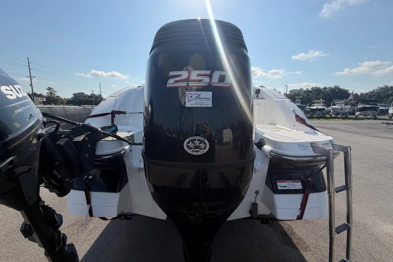 Slide: The Image of Un Hurricane SunDeck 2400 OB de 2019 avec un grand moteur hors-bord, garé sur un terrain. - 3