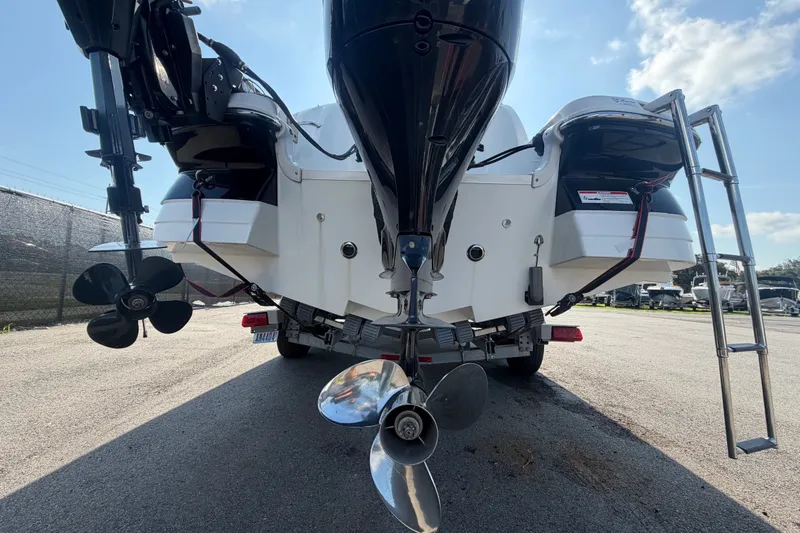 Slide: The Image of 2019 Hurricane SunDeck 2400 OB boat rear view with dual propellers and ladder. - 4