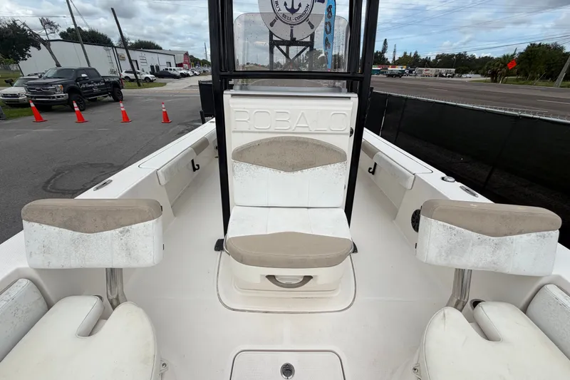 Slide: The Image of 2019 Robalo 226 Cayman boat interior with seating and console, parked outdoors. - 53