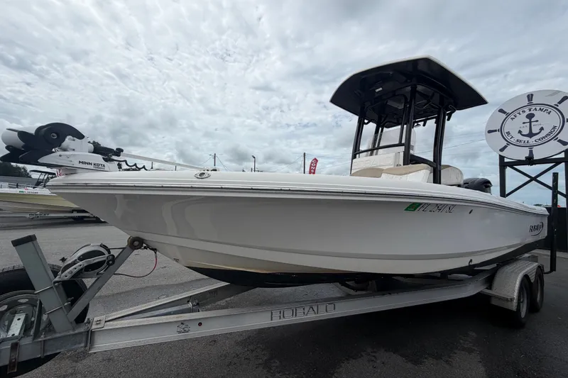 Slide: The Image of 2019 Robalo 226 Cayman boat on trailer under cloudy sky. - 9