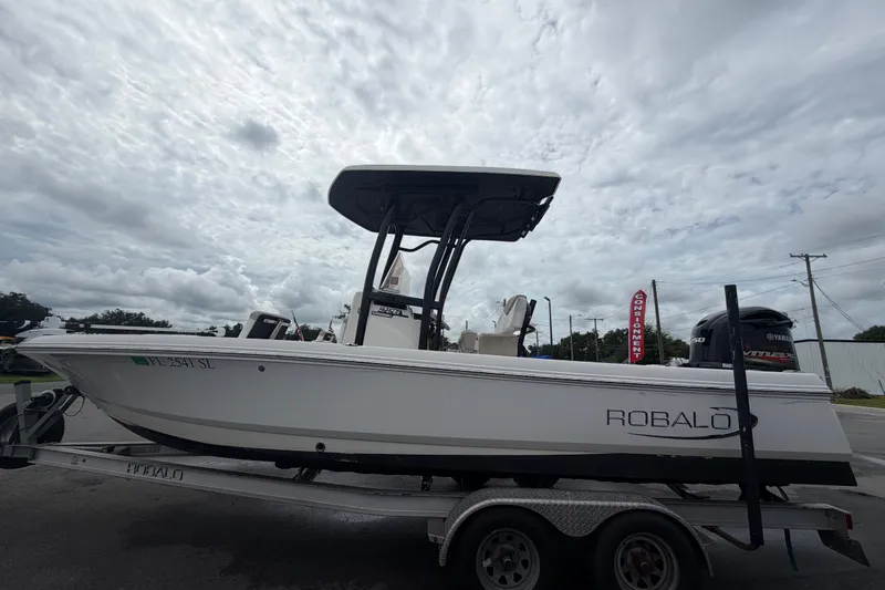 Slide: The Image of 2019 Robalo 226 Cayman boat on trailer under cloudy sky. - 8
