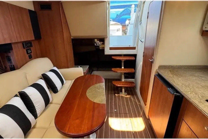 Slide: The Image of Interior of 2009 Cruisers Yachts 330 Express, featuring cozy seating and elegant wooden finishes. - 14