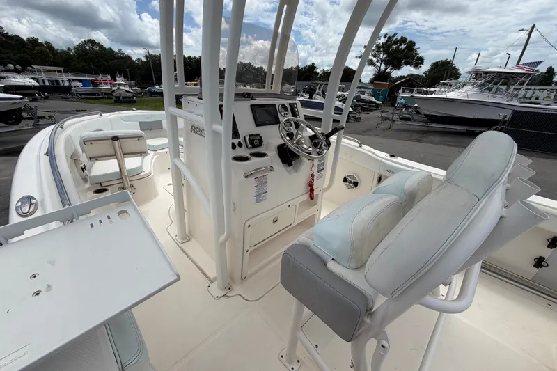 Slide: The Image of La imagen muestra la cabina de un barco Robalo R222 Center Console de 2019 con timón y área de asientos. - 31