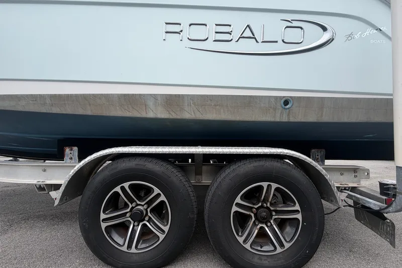 Slide: The Image of 2019 Robalo R222 Center Console boat on trailer, showcasing brand logo and wheels. - 74