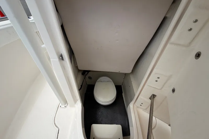 Slide: The Image of 2019 Robalo R222 Center Console boat interior with compact marine toilet. - 50