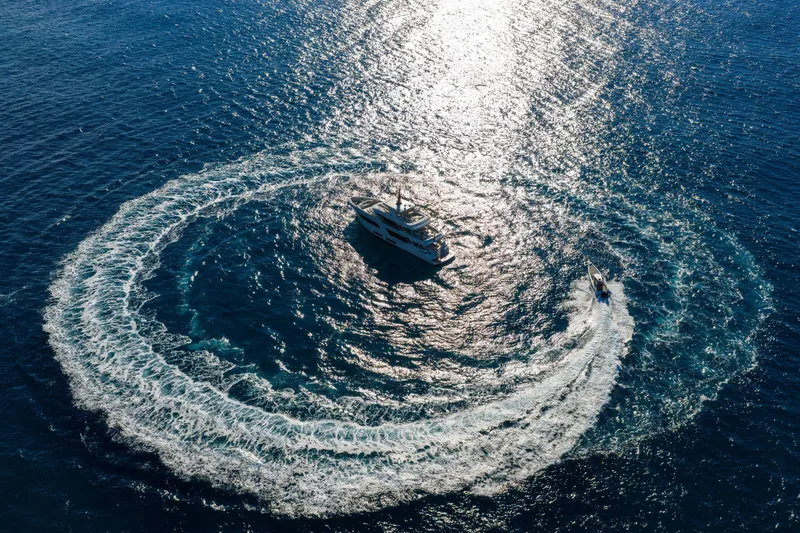 Slide: The Image of Aerial view of 2023 Cantiere Delle Marche RJ 115 yacht in ocean, creating circular wake. - 40