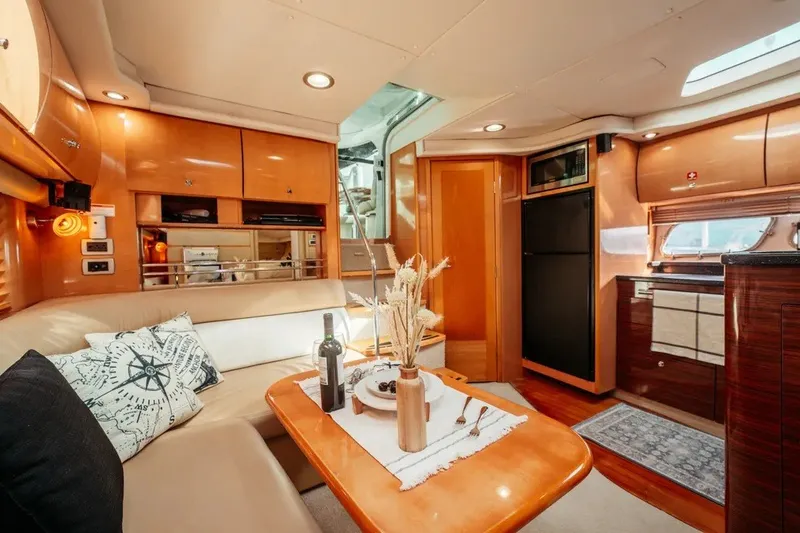 Slide: The Image of Luxurious 2009 Four Winns V458 yacht interior with elegant wood finishes and cozy seating area. - 16