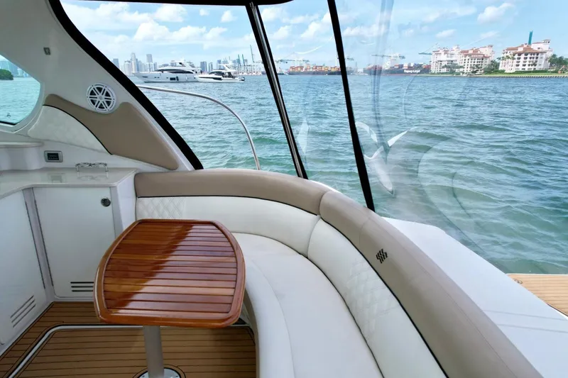 Slide: The Image of Interno di uno yacht di lusso con divano curvo e tavolo in legno, vista sull'acqua. - 36