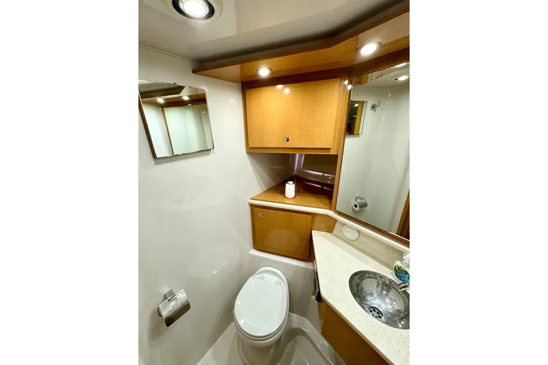 Slide: The Image of La imagen muestra un elegante baño de barco con gabinetes de madera y un lavabo moderno. - 32