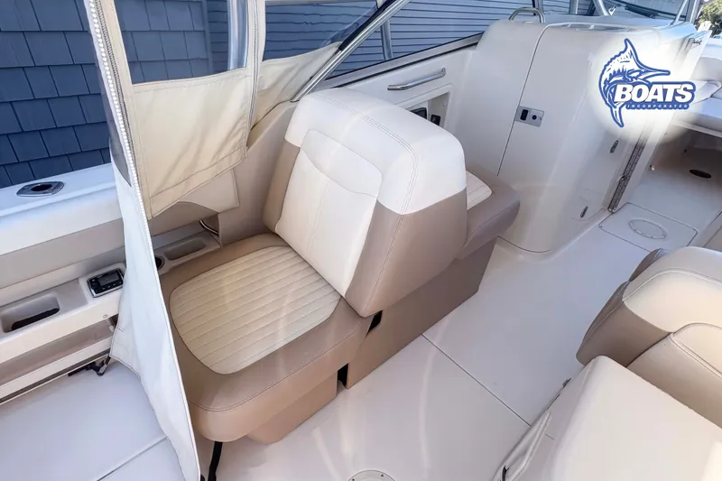 Slide: The Image of Interior of 2014 Grady-White Freedom 275 boat with beige seating and logo. - 12