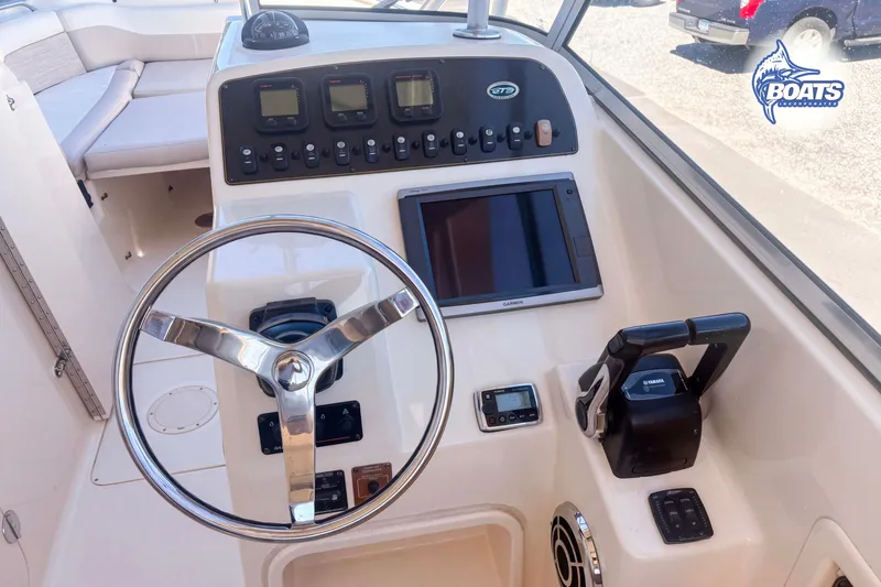 Slide: The Image of 2014 Grady-White Freedom 275 boat dashboard with steering wheel and controls. - 11