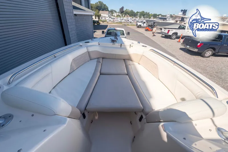 Slide: The Image of 2014 Grady-White Freedom 275 boat with spacious seating, parked near a marina. - 6