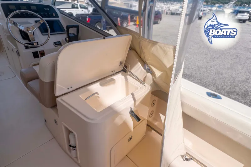 Slide: The Image of 2014 Grady-White Freedom 275 boat interior with helm and storage compartment. - 13
