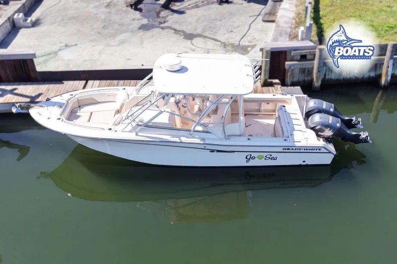 Slide: The Image of 2014 Grady-White Freedom 275 boat docked, featuring dual engines and spacious seating. - 4