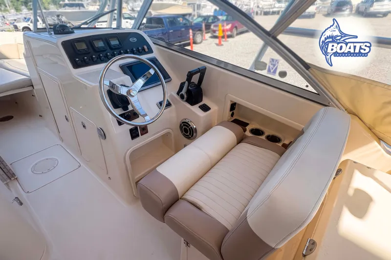 Slide: The Image of 2014 Grady-White Freedom 275 boat cockpit with steering wheel and control panel. - 10