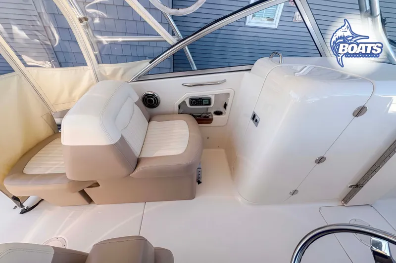 Slide: The Image of 2014 Grady-White Freedom 275 boat interior with beige seating and control panel. - 8