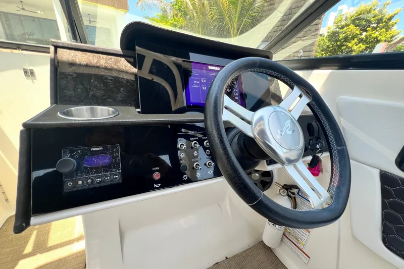 Slide: The Image of 2019 Sea Ray SDX 270 Outboard helm with steering wheel and control panel. - 84