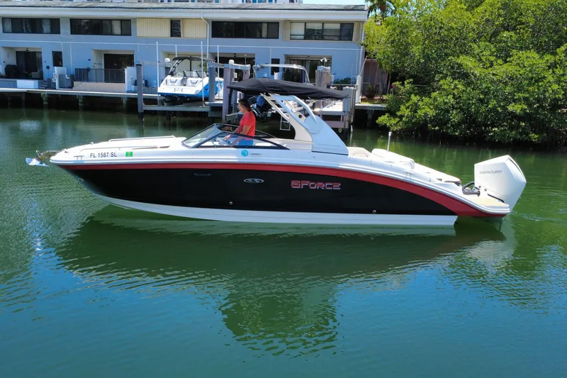 Slide: The Image of 2019 Sea Ray SDX 270 Outboard boat on calm water near dock. - 17