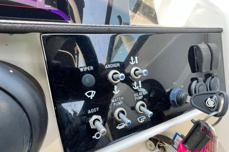 Slide: The Image of Control panel of a 2019 Sea Ray SDX 270 Outboard boat with switches and keys. - 90