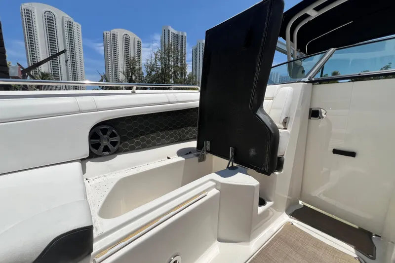 Slide: The Image of 2019 Sea Ray SDX 270 Outboard interior with seating and storage, city skyline in background. - 62
