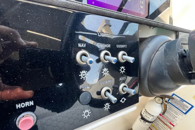 Slide: The Image of Control panel of a 2019 Sea Ray SDX 270 Outboard boat with various switches. - 89
