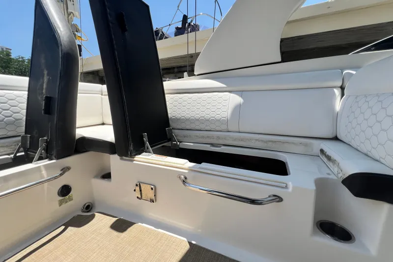 Slide: The Image of 2019 Sea Ray SDX 270 Outboard interior with open storage compartments and white seating. - 36