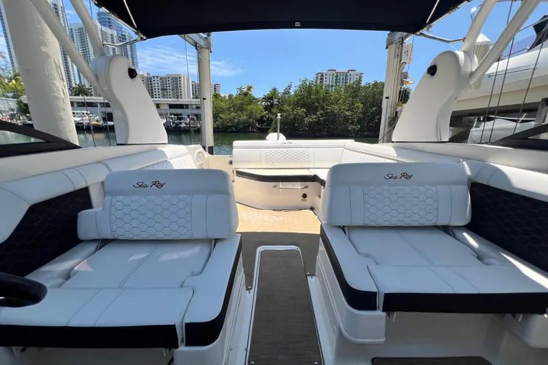 Slide: The Image of 2019 Sea Ray SDX 270 Outboard boat interior with white seating and waterfront view. - 44