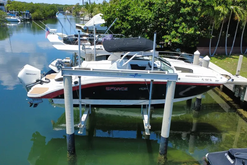 Slide: The Image of 2019 Sea Ray SDX 270 Outboard boat docked on a lift in a scenic canal. - 14