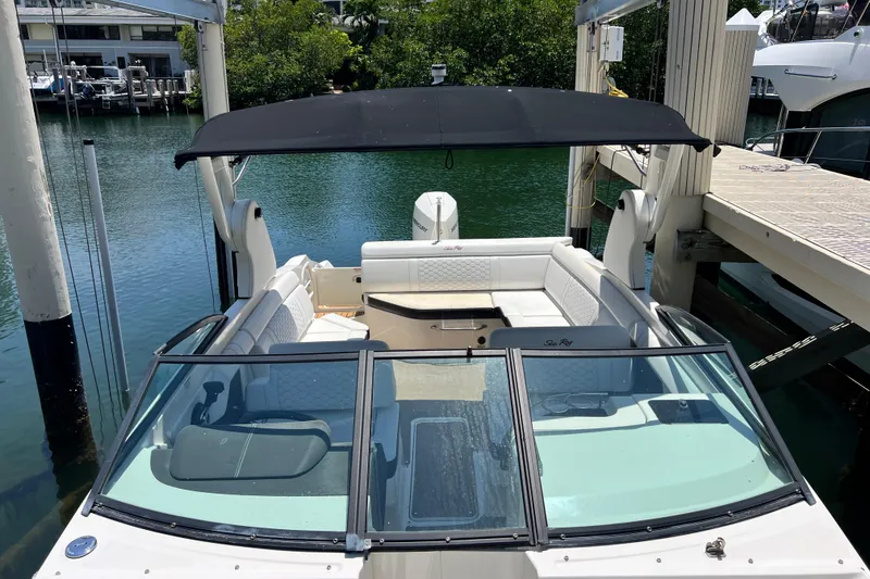 Slide: The Image of 2019 Sea Ray SDX 270 Outboard boat docked, featuring spacious seating and a black canopy. - 52