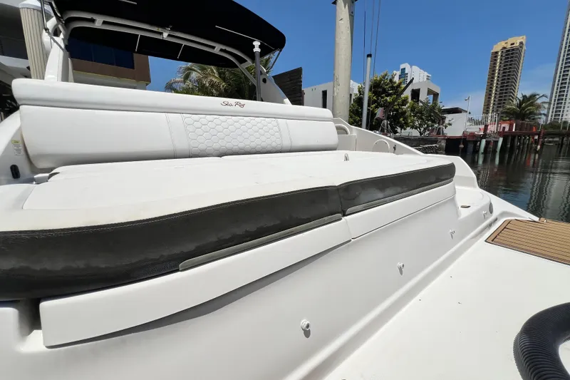 Slide: The Image of 2019 Sea Ray SDX 270 Outboard boat with white seating, docked near waterfront buildings. - 98