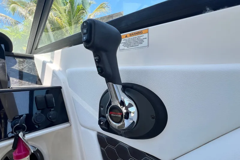 Slide: The Image of Throttle control of 2019 Sea Ray SDX 270 Outboard boat, with warning label and palm trees. - 87