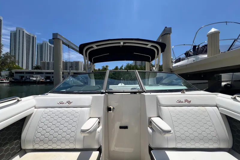 Slide: The Image of 2019 Sea Ray SDX 270 Outboard boat interior with white seating, docked near cityscape. - 49