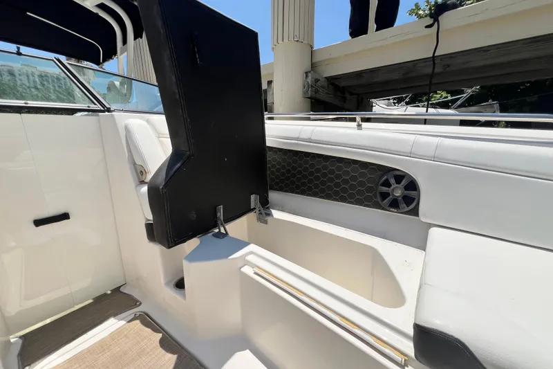 Slide: The Image of 2019 Sea Ray SDX 270 Outboard interior with open storage compartment and speaker. - 63