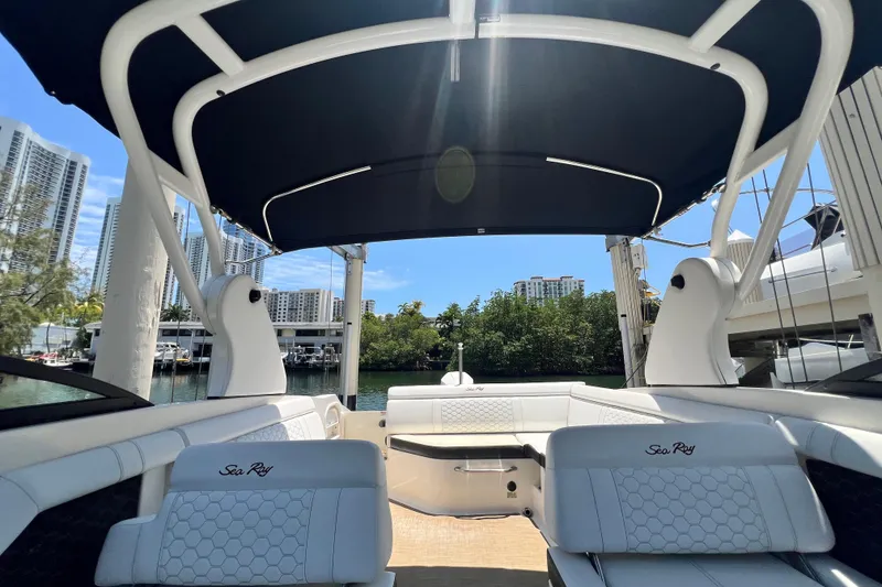 Slide: The Image of 2019 Sea Ray SDX 270 Outboard boat interior with canopy, docked near waterfront buildings. - 45