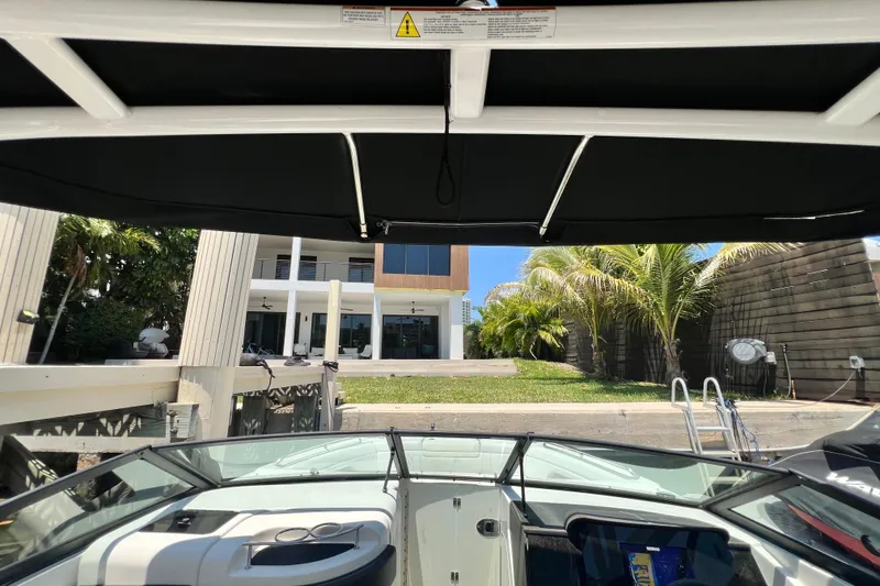 Slide: The Image of 2019 Sea Ray SDX 270 Outboard boat docked near a modern waterfront home. - 70