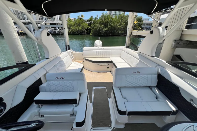 Slide: The Image of 2019 Sea Ray SDX 270 Outboard boat interior with white seating and scenic waterfront view. - 42