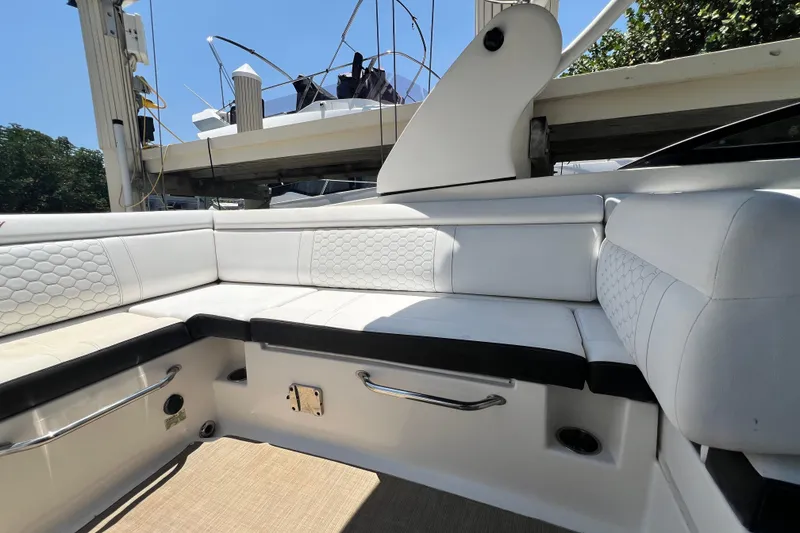 Slide: The Image of 2019 Sea Ray SDX 270 Outboard interior with white cushioned seating and sleek design. - 32