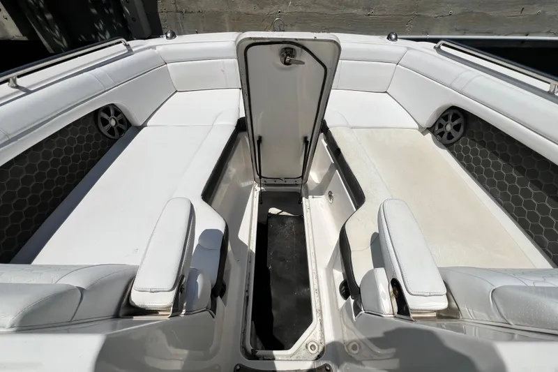 Slide: The Image of 2019 Sea Ray SDX 270 Outboard interior with open storage compartment and white seating. - 99