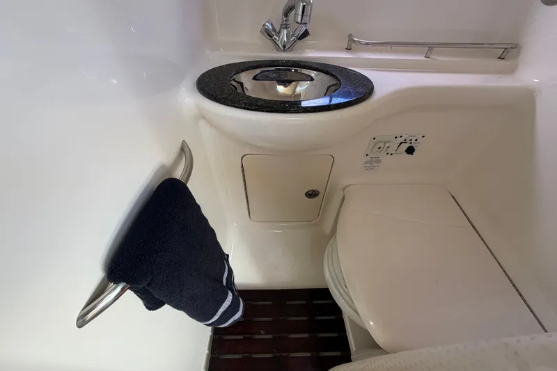 Slide: The Image of 2008 Chaparral Signature 290 boat bathroom with sink, towel, and toilet. - 86
