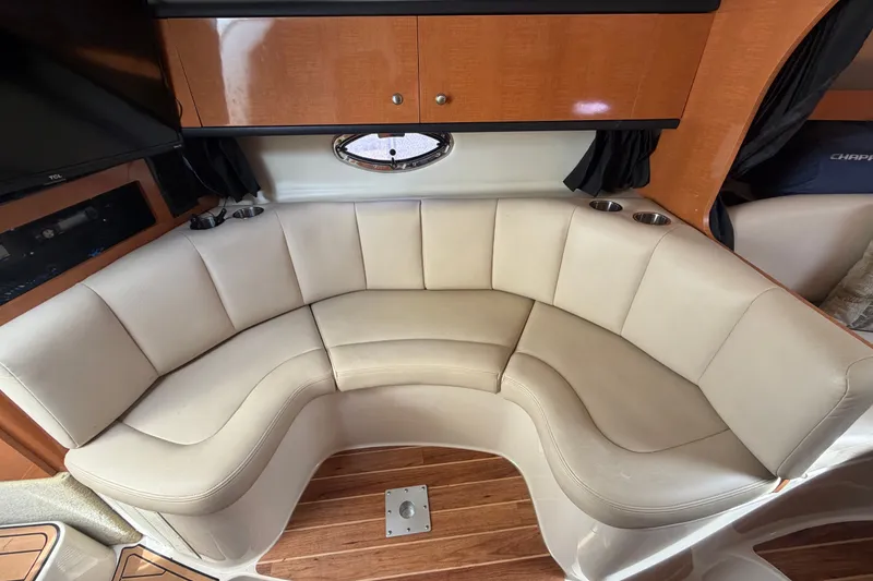Slide: The Image of 2008 Chaparral Signature 290 interior with curved beige seating and wooden accents. - 55