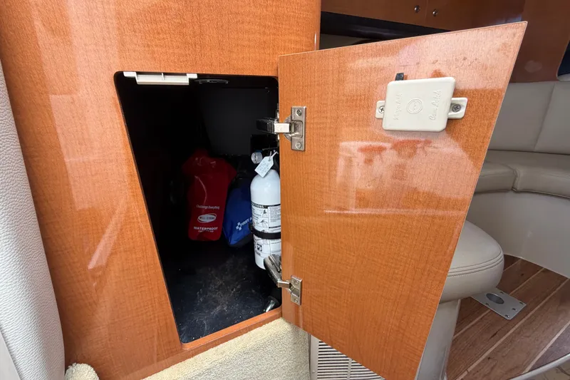 Slide: The Image of Open cabinet on 2008 Chaparral Signature 290 boat, revealing storage with fire extinguisher. - 48