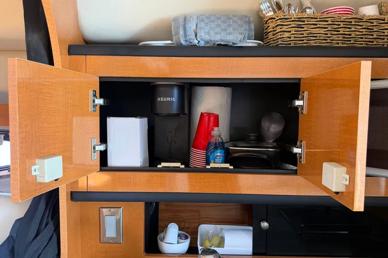 Slide: The Image of Open cabinet in 2008 Chaparral Signature 290 with Keurig, cups, and kitchen supplies. - 73