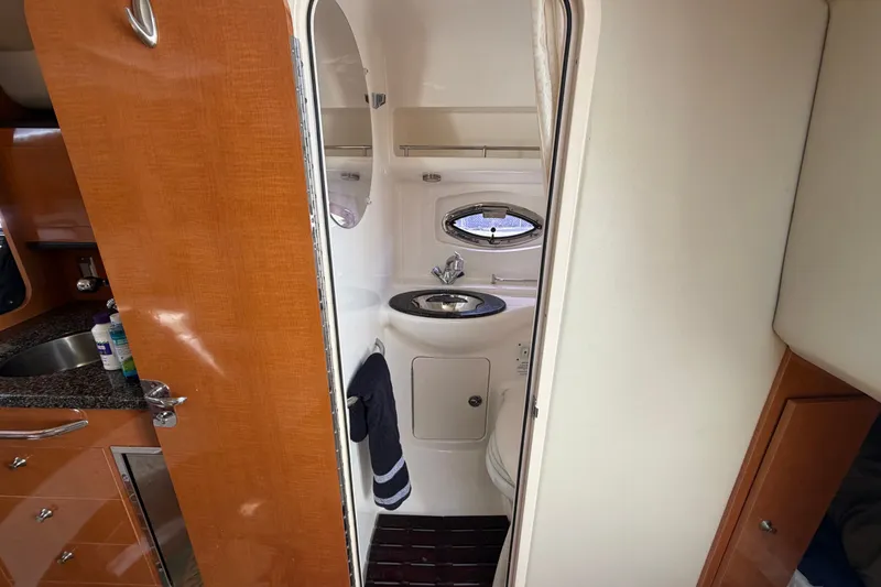 Slide: The Image of Interior of 2008 Chaparral Signature 290 boat bathroom with sink and porthole window. - 84