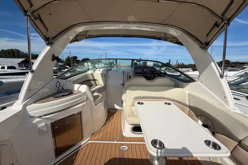 Slide: The Image of 2008 Chaparral Signature 290 boat interior with seating, table, and helm under canopy. - 11