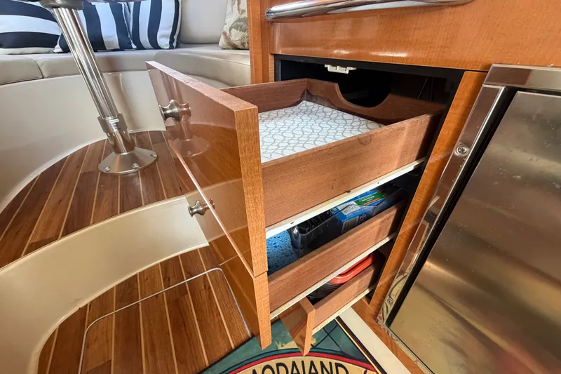 Slide: The Image of 2008 Chaparral Signature 290 interior with open wooden drawers and striped cushions. - 80