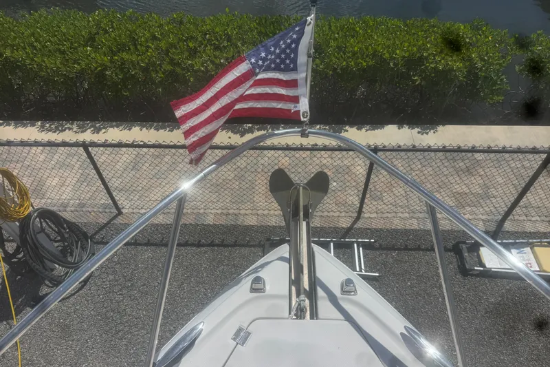 Slide: The Image of Bow view of 2008 Chaparral Signature 290 with American flag, docked near greenery. - 40
